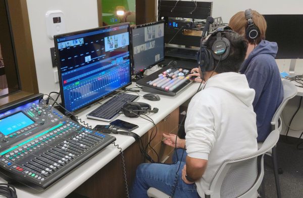 Enlace staff producer Jesus Delgado trains a TAMUSA Esports team member on how to use a live broadcast switcher. TAMUSA Esports stated producing their podcast with the support of Enlace Media Lab in the Spring of 2023.